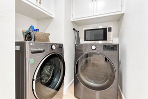 A laundry area with two front-loading washing machines and a microwave above them. - 4BR Austin Escape Sleeps 9 | Patio, & Fire Pit (Austin)