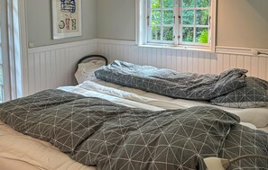 A bedroom with a bed, a window with a view of greenery, and a wall-mounted picture. - Stunning home in Herning with WiFi (Herning)