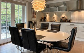 A dining area with a round table, black chairs, and a pendant light. - Stunning home in Herning with WiFi (Herning)