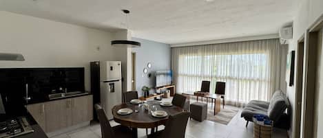 A modern living space with a kitchen, dining area, and seating area.