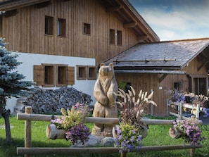 Un edificio in legno con una scultura di un orso di fronte.