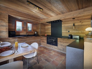Una cucina moderna con elementi in legno, un'area pranzo con tavolo imbandito per due persone e vista dalla finestra.