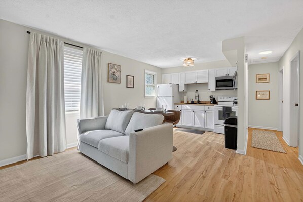Eine moderne Wohnung mit Wohnzimmer, Küche und Essbereich.