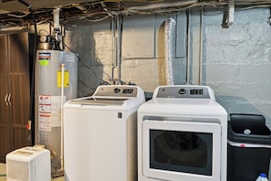 A laundry area with a water heater, two dryers, and a trash bin. - Walk to Sparrow I 2 BR I 1 BA (Lansing)