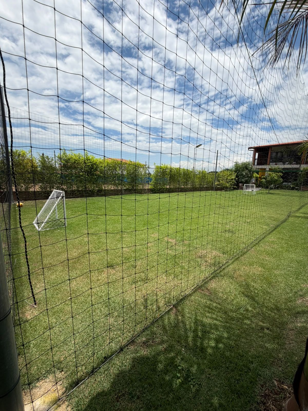 Un'area esterna recintata con un palo da calcio, probabilmente un campo sportivo.