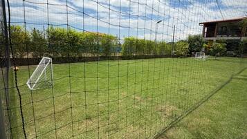 Un'area esterna recintata con un palo da calcio, probabilmente un campo sportivo.