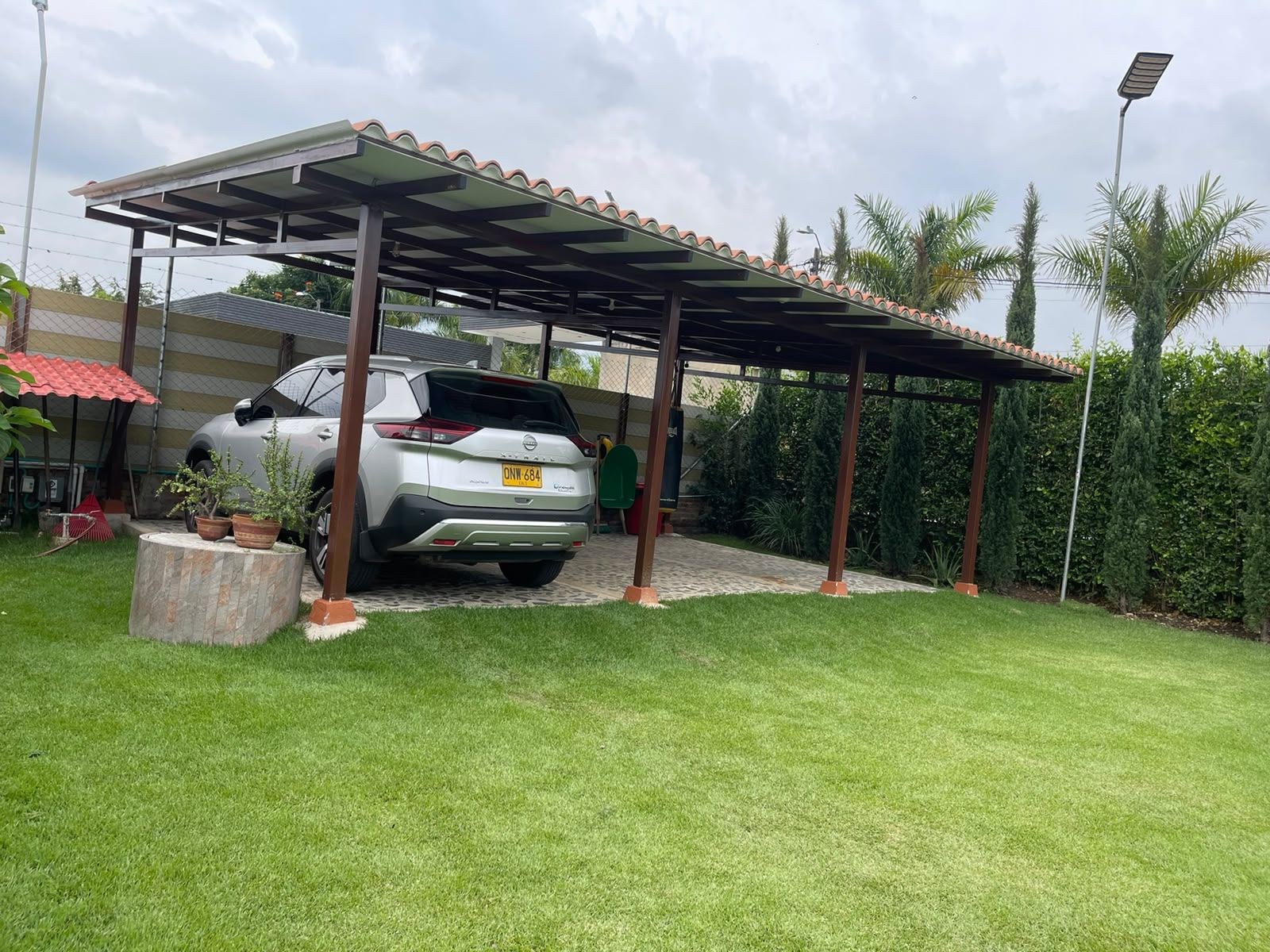 A covered parking area with a car parked underneath.
