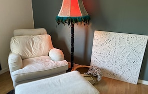 A room with a beige armchair, a floor lamp with a decorative shade, and a textured wall panel. - 1 bedroom amazing apartment in Jädraås (Jädraås)