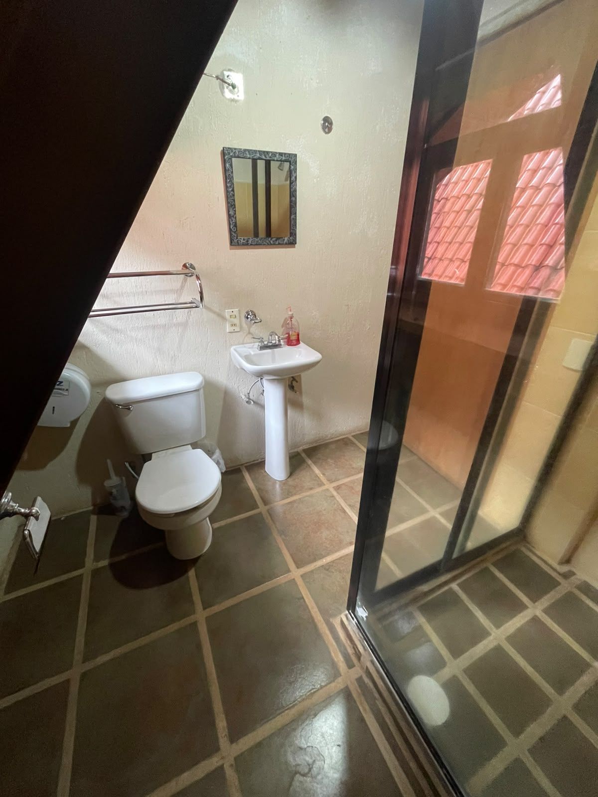 Een badkamer met toilet, wastafel en douche.