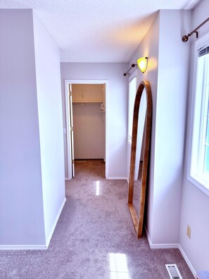 A hallway with a closet, a mirror, and a window. - 3 Bedroom Family Home in NW Calgary (Calgary)
