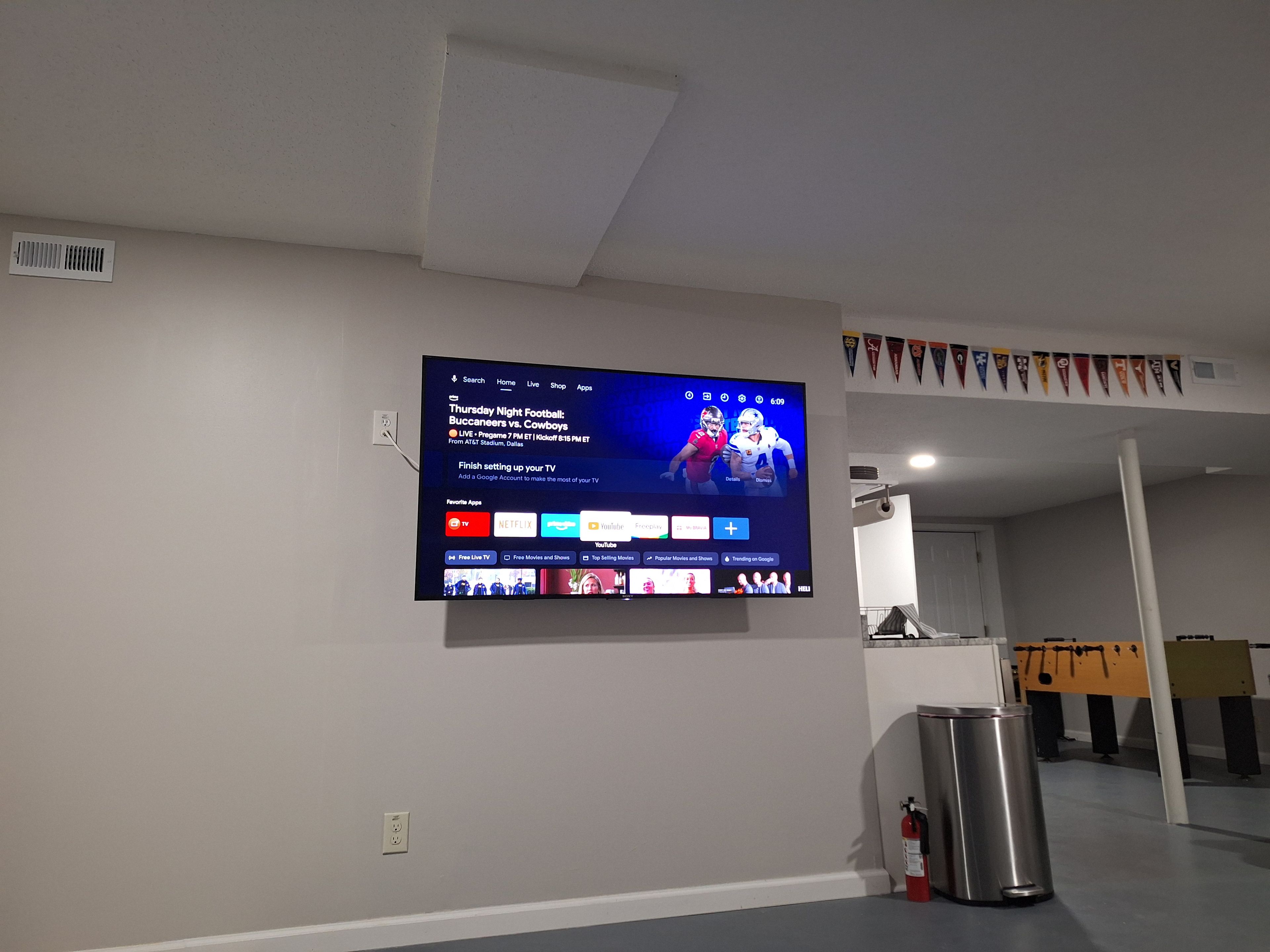 A flat-screen TV mounted on a wall displaying a sports event.