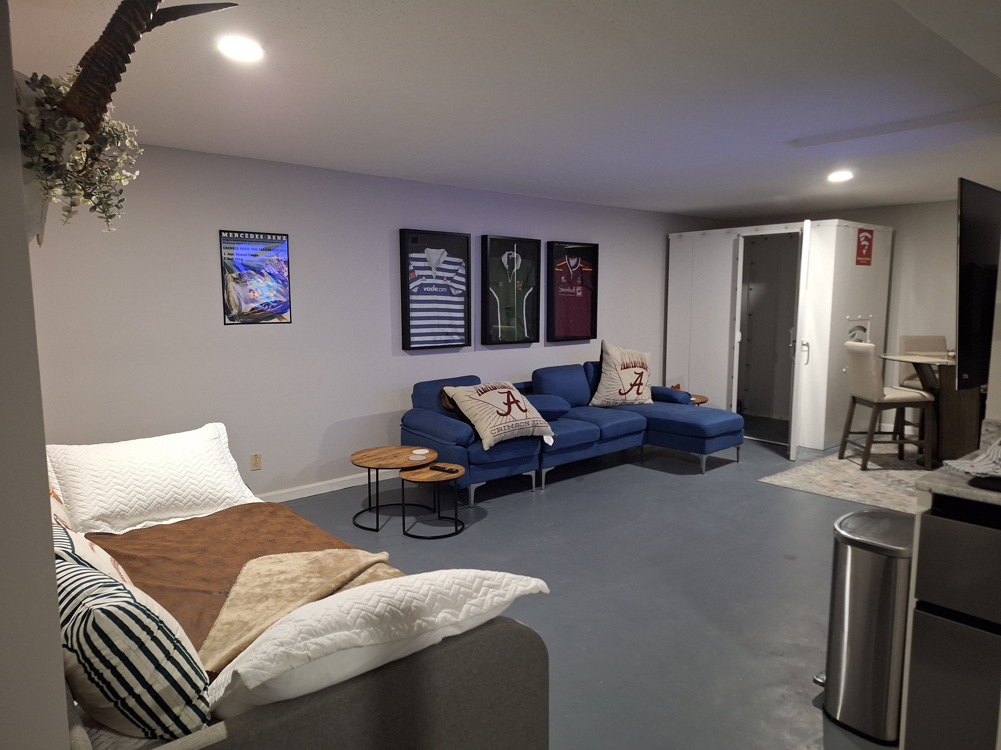 A modern living room with a sectional sofa, a small coffee table, and a TV mounted on the wall.