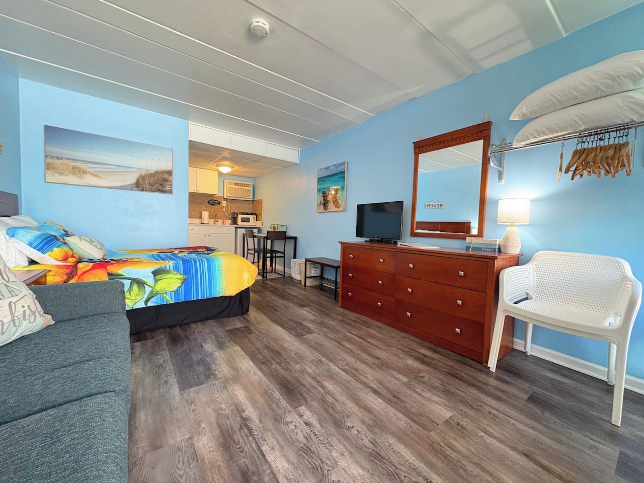 Une pièce comprenant un lit, une commode, un téléviseur et une chaise.