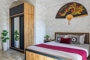 A bedroom with a bed, bedside tables, a nightstand, a large mirror, and a decorative fan. - Apartments Zarafshan city 5 Tashkent (Tashkent)