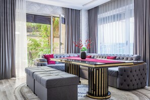 A modern living room with a sectional sofa, ottomans, a coffee table, and a vase with red flowers. - Apartments Zarafshan city 5 Tashkent (Tashkent)