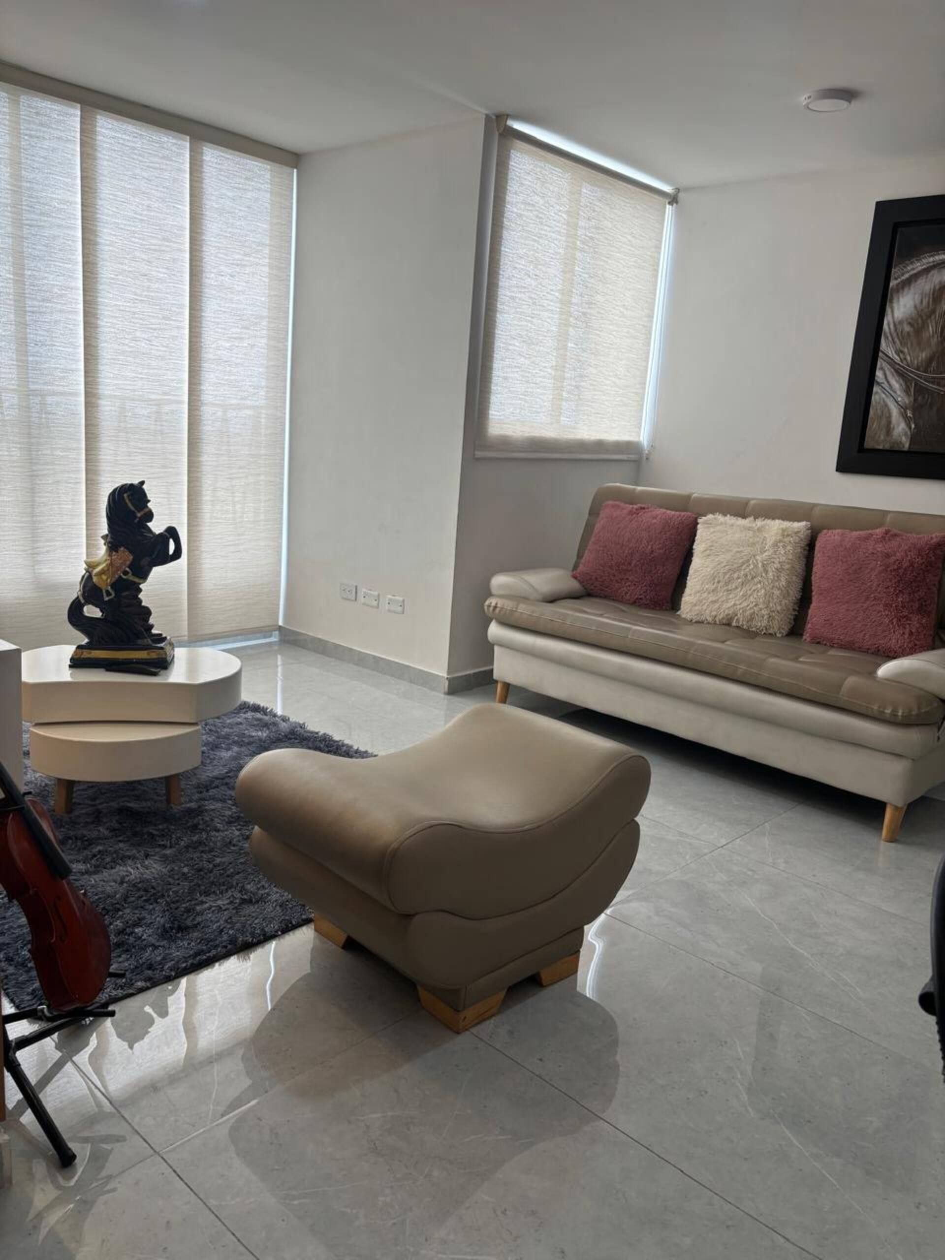 A modern living room with a sofa, a small round table, and a decorative sculpture.