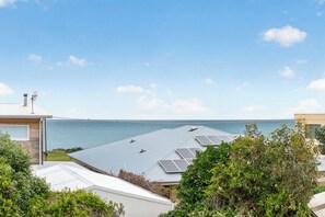 A residential area with a view of the sea, solar panels on the roof, and a satellite dish. - Seaside Family Escape 5 Bedrooms Sea Views (Middleton)