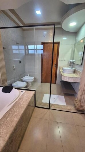 A bathroom with a glass-enclosed shower, a bathtub, and a vanity with a sink and mirror. - Hibisco Hotel Boutique (Encarnación)