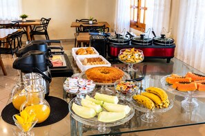 A buffet setup with various food items and a coffee machine. - Hibisco Hotel Boutique (Encarnación)