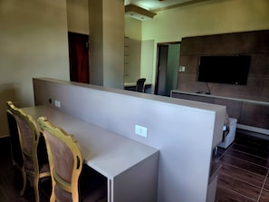 A modern office space with cubicles, a television on the wall, and a desk with chairs. - Hibisco Hotel Boutique (Encarnación)