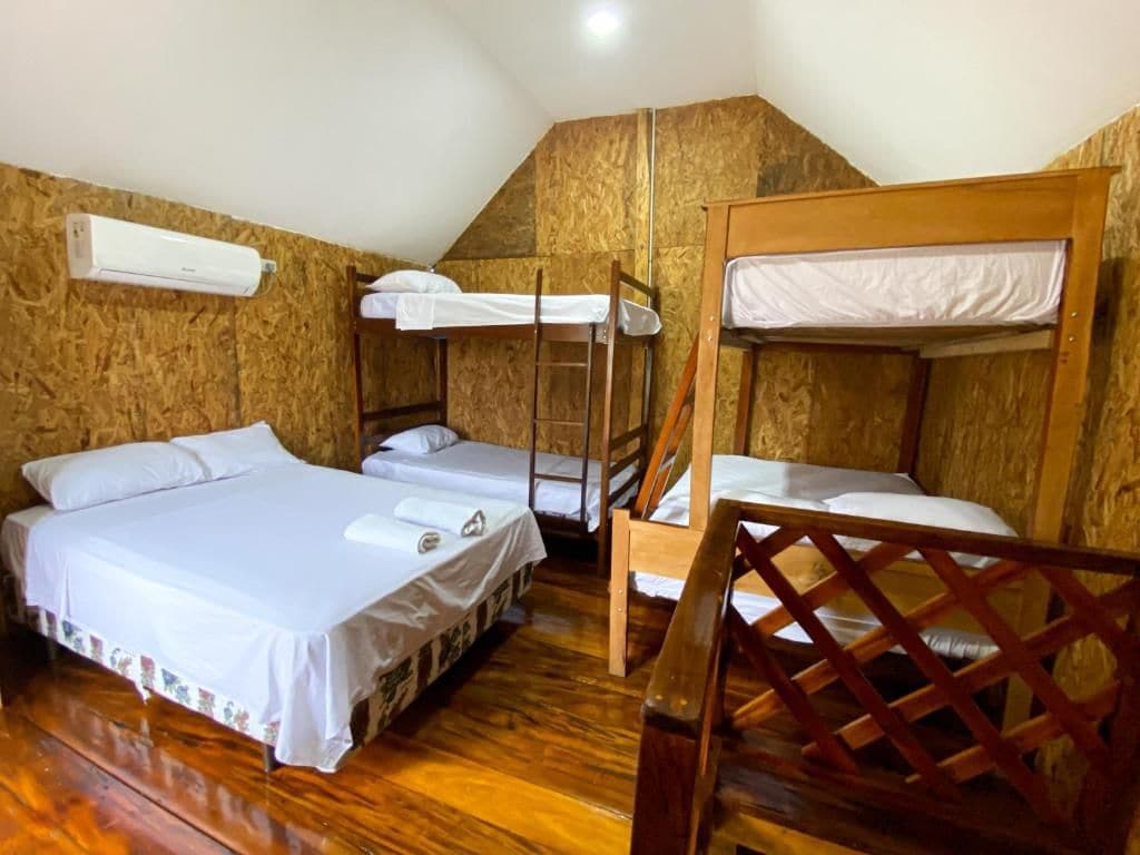 A room with bunk beds, a wooden floor, and an air conditioning unit.