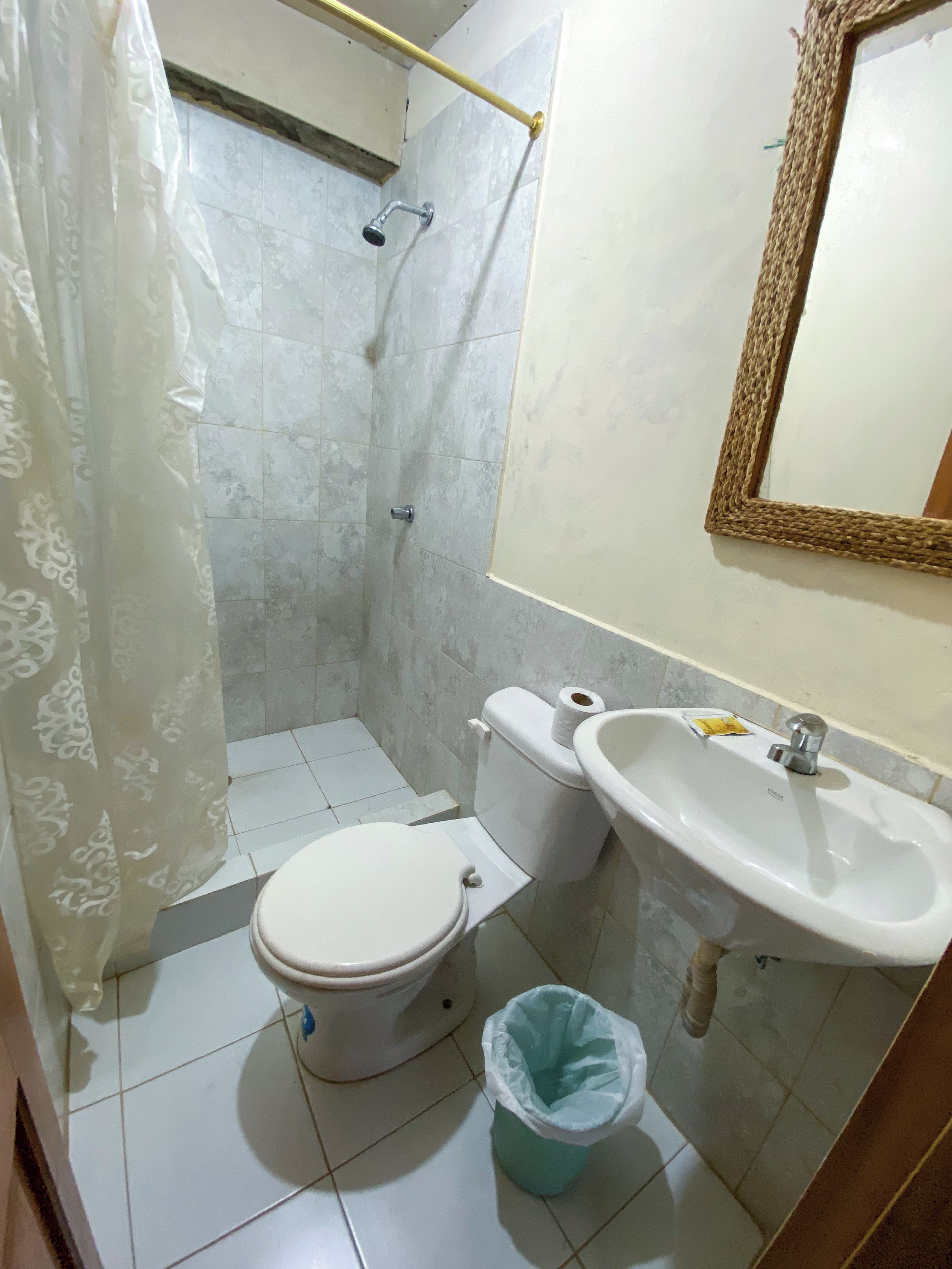Un baño con inodoro, lavabo y espejo.