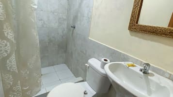 Un baño con inodoro, lavabo y espejo.