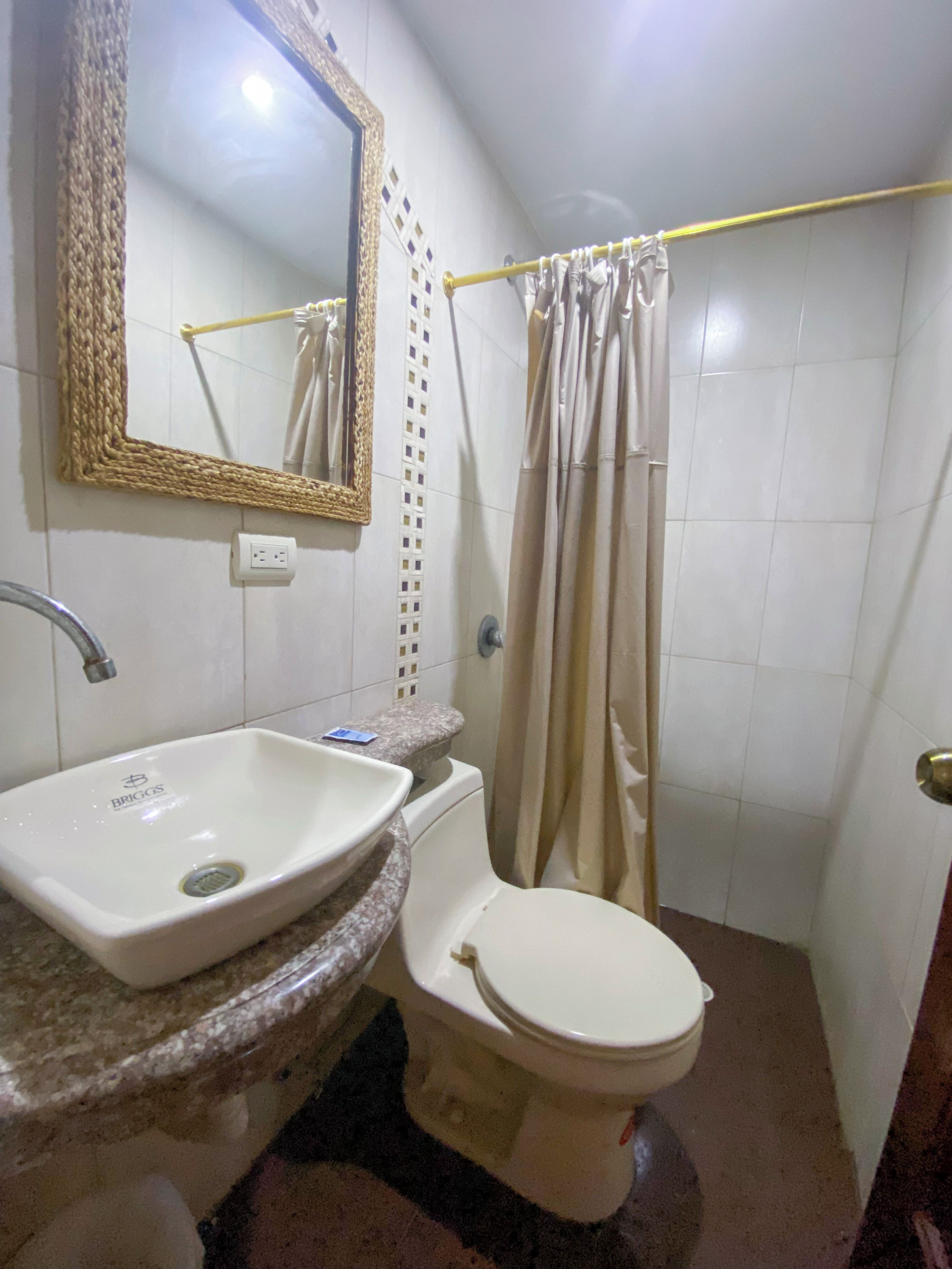 Un baño con lavamanos, inodoro y cortina de ducha.