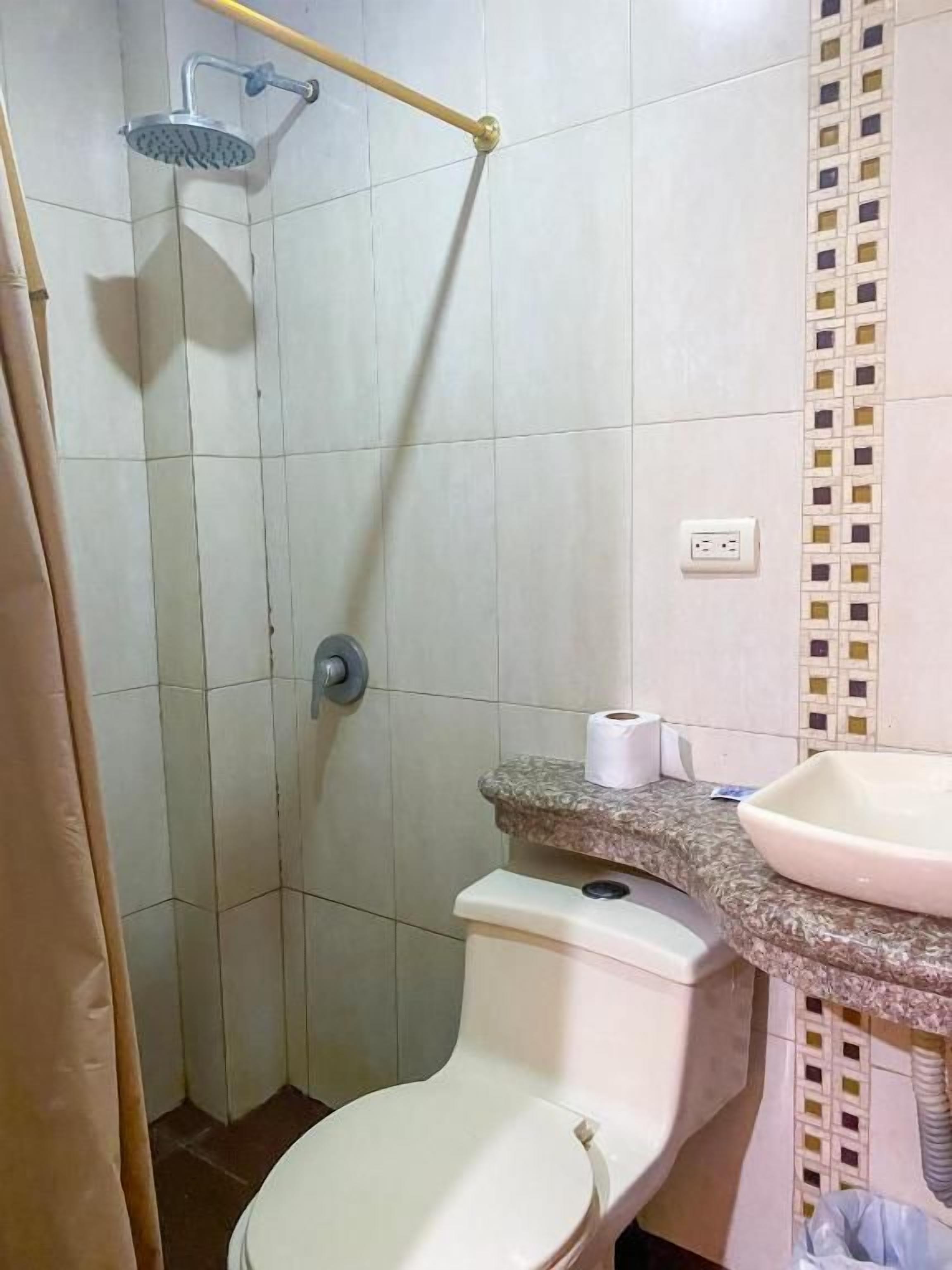 Un baño con ducha, inodoro y lavamanos.