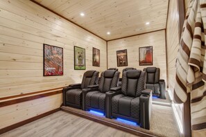 A room with wooden walls, a ceiling with recessed lighting, and a row of black massage chairs with blue LED lighting. - NEW Smoky Mountain Swim-Inn Private Pool, Arcade in Pigeon Forge Dog Friendly (Pigeon Forge)