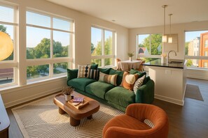 A modern living room with a green sofa, a wooden coffee table, and an orange armchair.