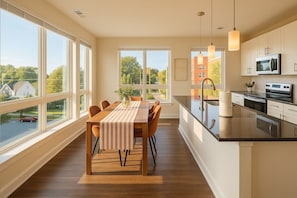 A modern kitchen with a large island, a dining area with a view, and a spacious living area with large windows.