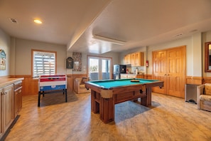 A pool table in a room with wooden cabinets and a window with blinds. - Resting Hearts - 4x4 Carova Beach, Ocean Views, Pool, Cargo Lift, Up to 4 Dogs OK, Flex Stays (Carova Beach)