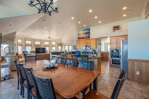 A spacious kitchen with wooden cabinets, a dining area with a large table and chairs, and a ceiling fan. - Resting Hearts - 4x4 Carova Beach, Ocean Views, Pool, Cargo Lift, Up to 4 Dogs OK, Flex Stays (Carova Beach)