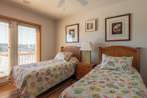 A bedroom with two beds, a nightstand, a lamp, and framed artwork on the wall. - Resting Hearts - 4x4 Carova Beach, Ocean Views, Pool, Cargo Lift, Up to 4 Dogs OK, Flex Stays (Carova Beach)