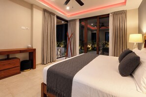 A hotel room with a bed, a desk, a lamp, and a view of the outside. - Villa Almarez | Private Luxury Retreat (Tulum)