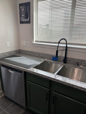 A kitchen with a double sink, a dishwasher, and a window with blinds. - Huge Modern 4Bdr home-The Xperience #2 (Houston)