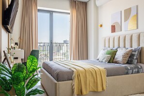 A hotel room with a bed, a chair, a desk, and a large window with curtains. - Apartments Nukus avenue Tashkent (Tashkent)