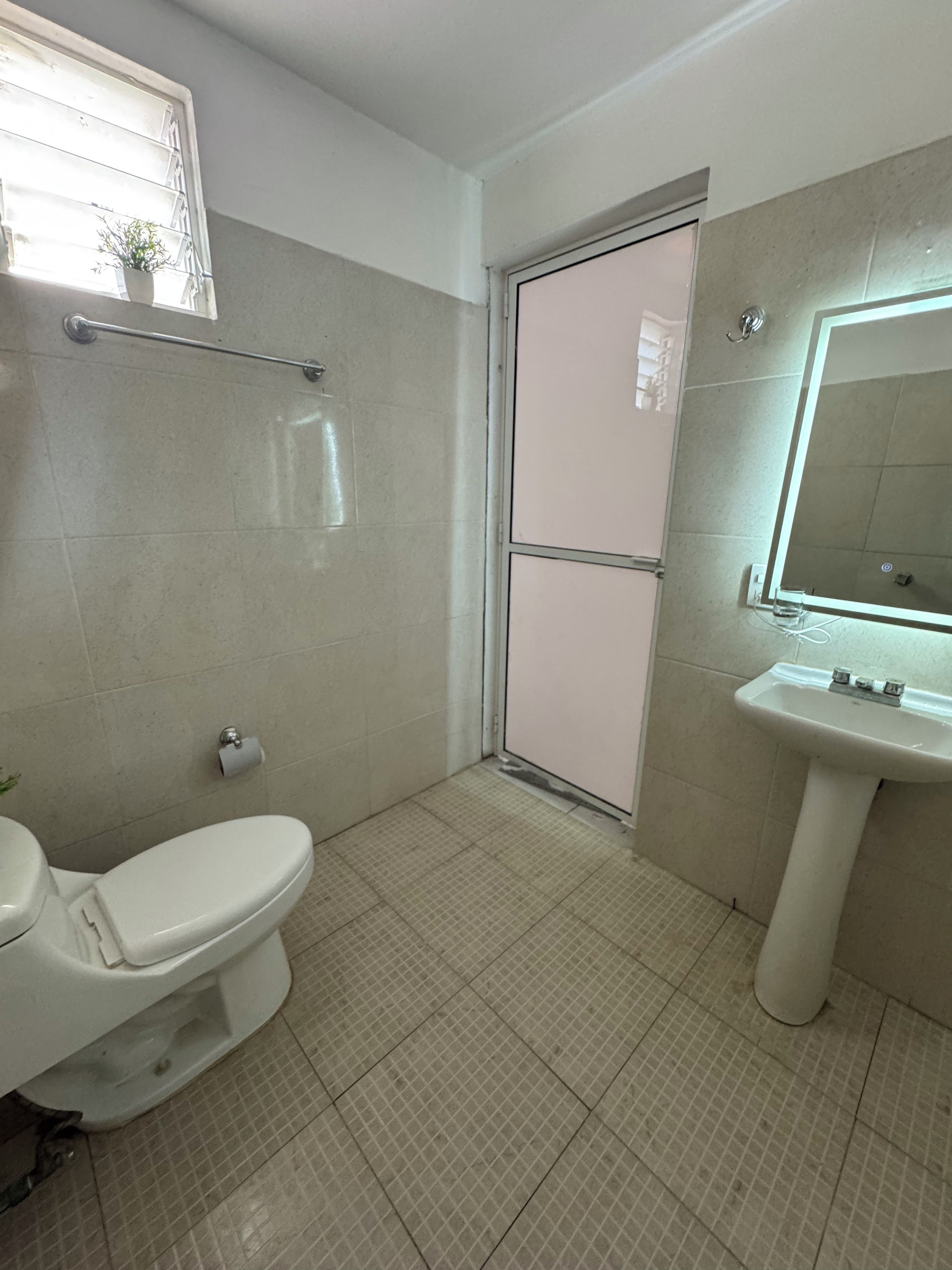 A bathroom with a toilet, a sink, and a shower area.