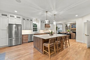 A modern kitchen with a central island, stainless steel appliances, and pendant lighting. - Luxury Owl’s Nest Retreat Golf & Resort (Campton)