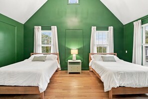 A room with two beds, a nightstand with a lamp, and a window with curtains. - Luxury Owl’s Nest Retreat Golf & Resort (Campton)