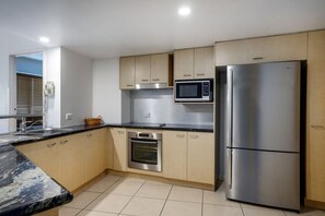 A modern kitchen with wooden cabinets, a stainless steel refrigerator, a microwave, and an oven. - 3 Bedroom Oceanfront Balcony (Kings Beach)