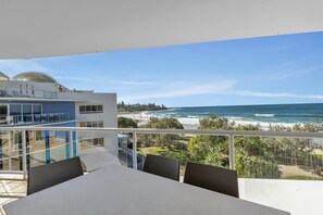 A balcony with a view of the ocean and a modern building. - 3 Bedroom Oceanfront Rooftop (Kings Beach)