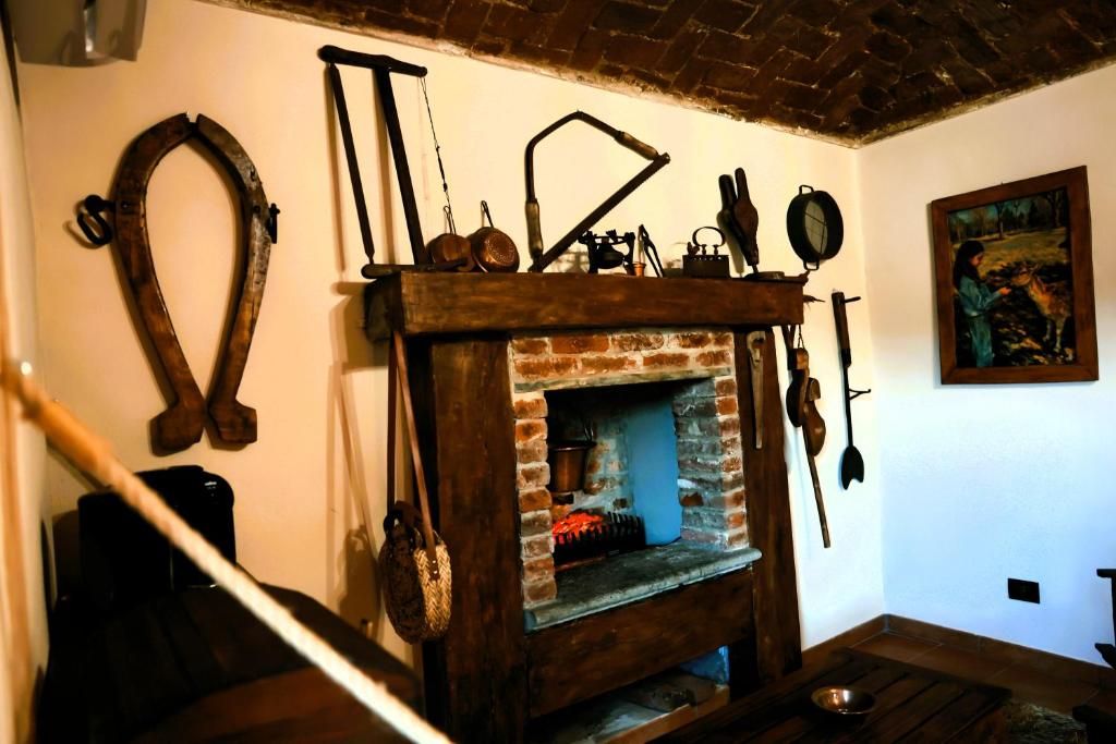 A rustic room with a brick fireplace, wooden tools, and a painting on the wall.