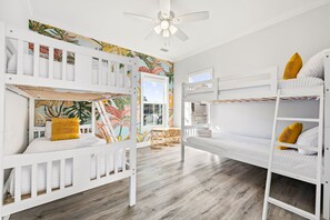 Ein Zimmer mit Etagenbetten, einem Deckenventilator und einem Fenster mit Blick.
