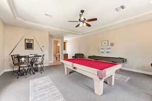 A room with a pool table, a ceiling fan, and a dining area with chairs. - Waterfront Fun, Pool & Spa Paradise with Game Room & Gulf Access - Palm Vista Villa - Roelens (Cape Coral)