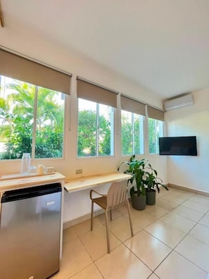 Cozinha moderna com máquina de lavar louça embutida, bancada de madeira e janela com vista para o verde.