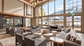 A spacious indoor area with multiple seating arrangements, large windows, and a fireplace. -  Ritz- Carlton Club ,Vail, Colorado Cozy 2-bedroom residence,2.5 Bathroom (Vail)