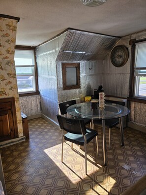 A dining area with a round table, chairs, and a clock on the wall. - Charming 2-bedroom apartment  in Springfield (Springfield)