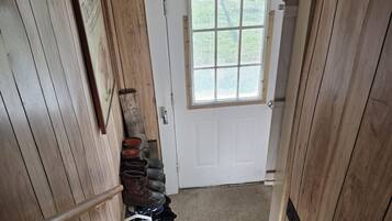 A wooden staircase leading to a white door with a window above it.